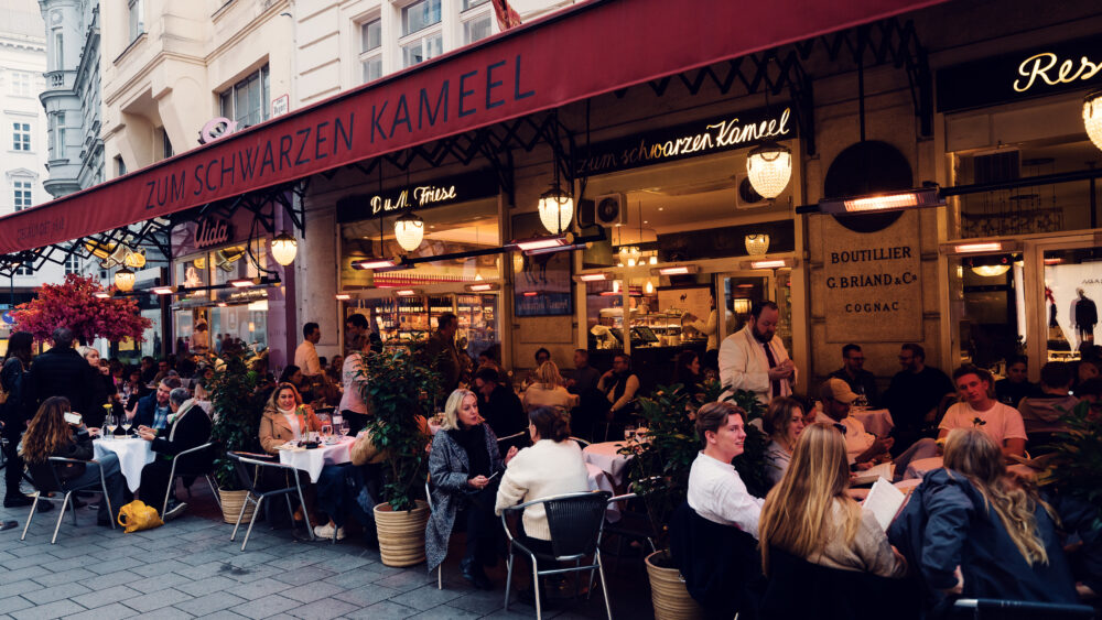 A lively street scene in front of the Viennese restaurant Zum Schwarzen Kameel